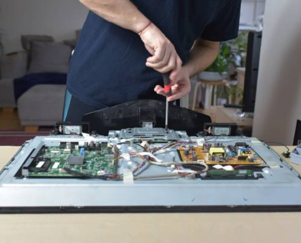 Technician opening a LED TV for repair at customer home