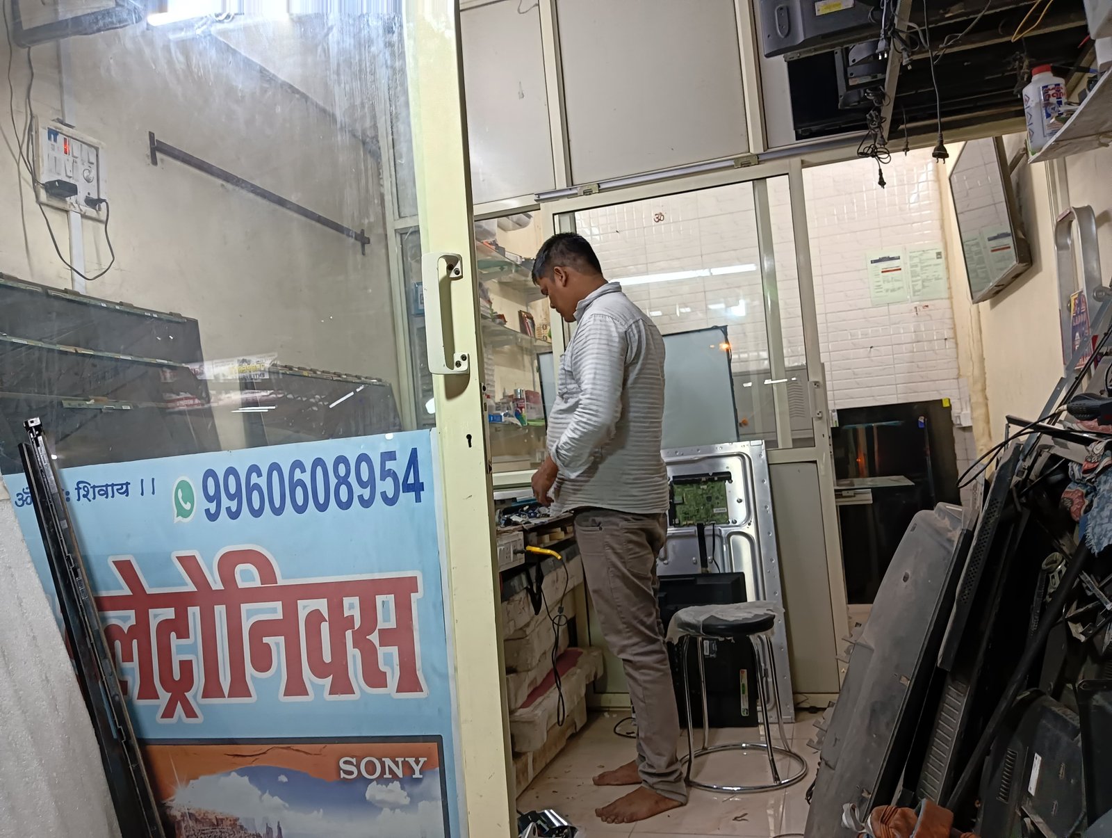 Shree Vijay Electronics TV repair shop with technician working on an LED TV panel